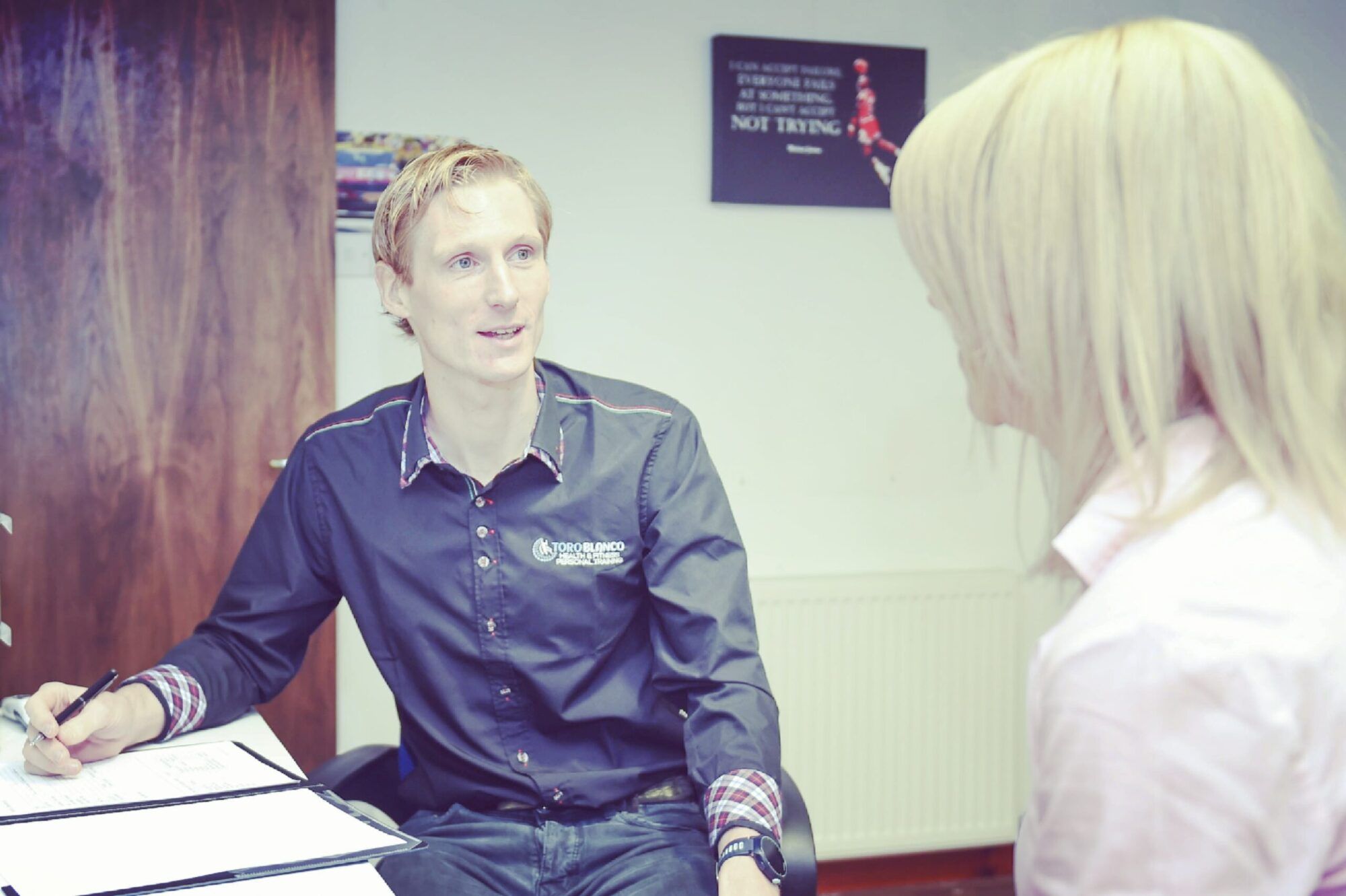 Chris Roy discussing a personalised health and fitness plan with a client